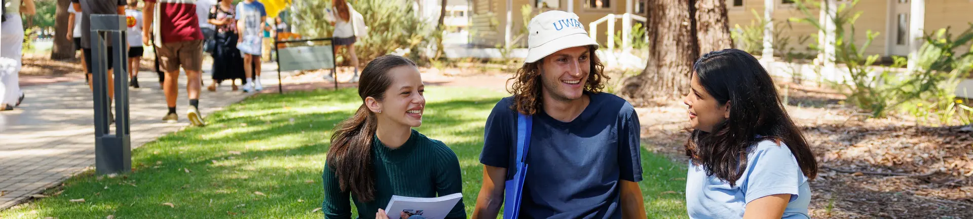 Students sitting on lawn with uwa merchandise