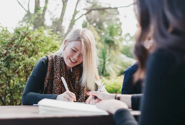 A women writing and smiling